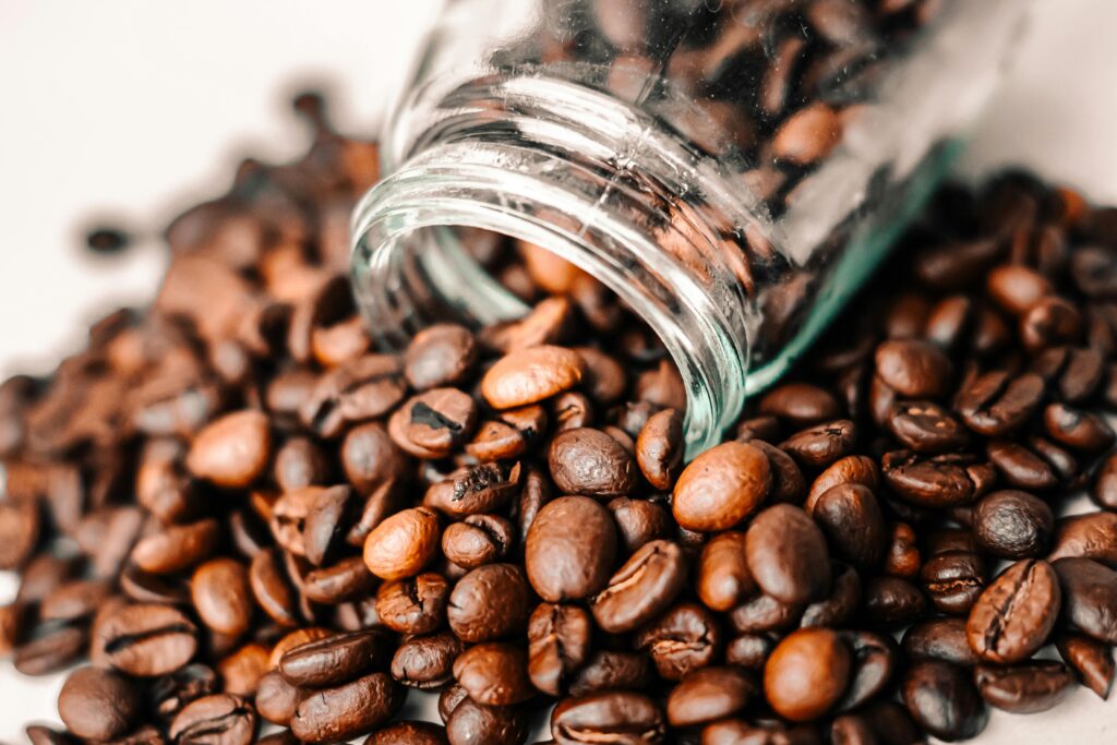 pexels-photo-17516410-17516410 A detailed shot of aromatic coffee beans spilling from a transparent glass jar onto a surface.